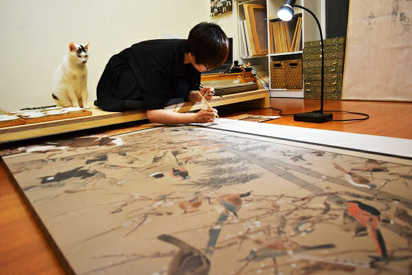 お行儀よく創作を見守る猫。会場にはアトリエの制作風景も展示しています。